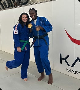 Genevieve Puglissi and Clarisse holding medals in front of the Kano Martial Arts wall